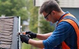 Technician performing a gutter inspection